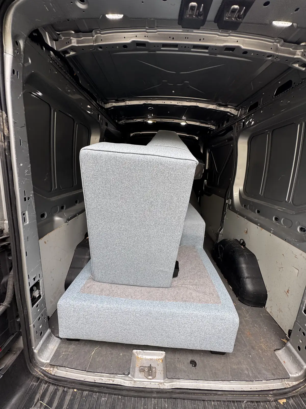 Grijze bank ingeladen in de bus van Grofvuil Ophalers