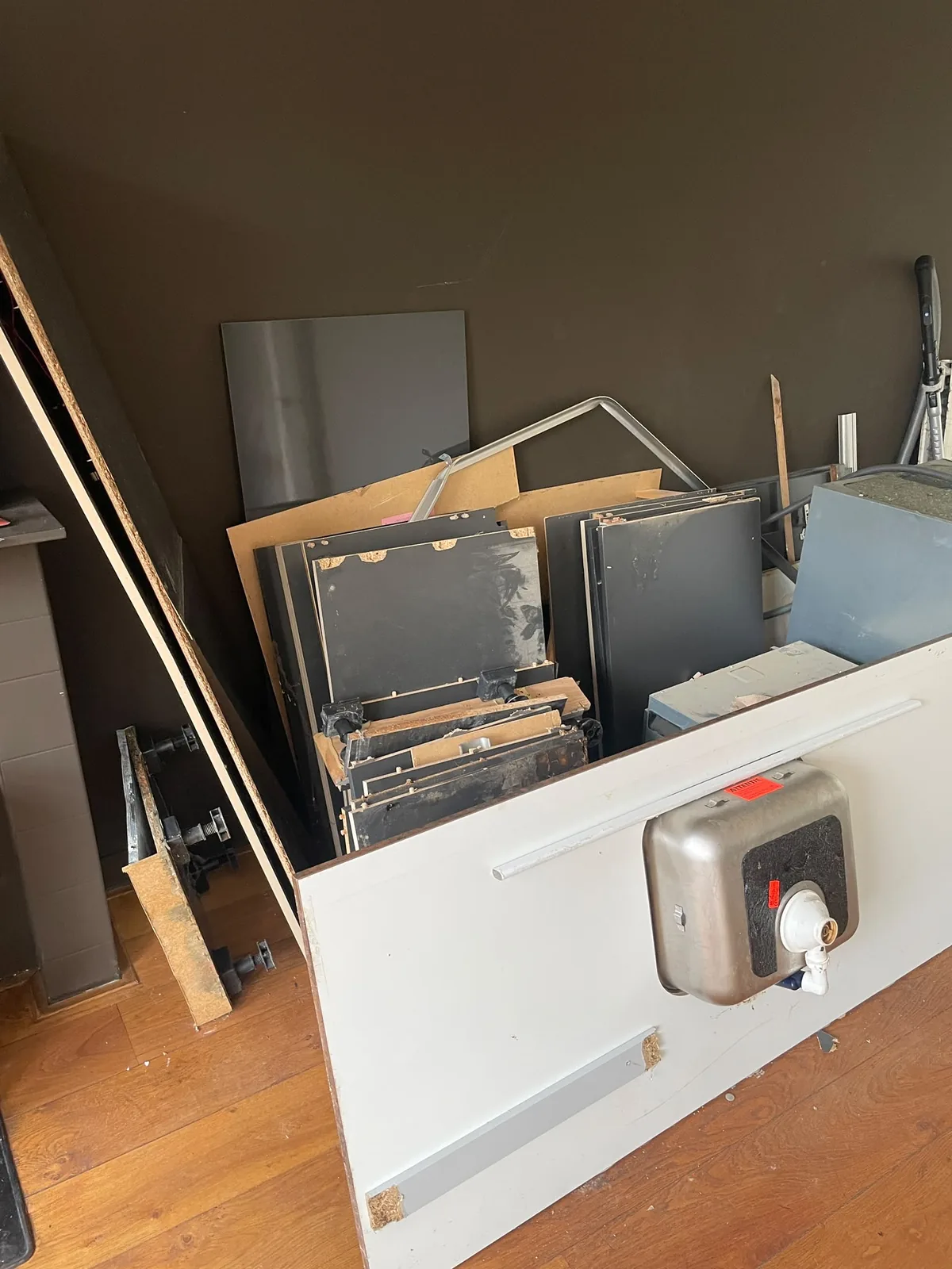 Gedemonteerde keukenkastjes en oude boiler, klaar voor afvoer